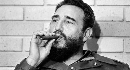 Fidel Castro, Prime Minister of Cuba, smokes a cigar during his meeting with two U.S. senators, the first to visit Castro's Cuba, in Havana, Cuba, Sept. 29, 1974. (AP Photo)