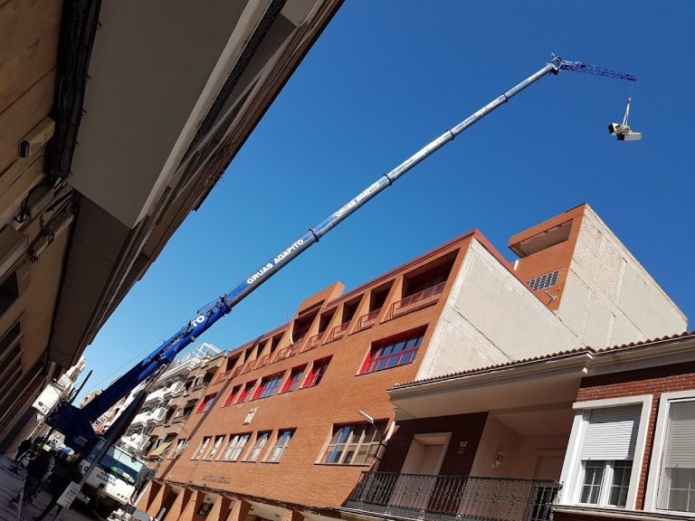 Espectacular maniobra de una grúa pluma en los juzgados de Puertollano