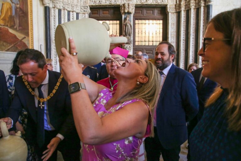 Milagros Tolón cumple con la tradición toledana de beber el agua de los botijos en el claustro de la Catedral Primada