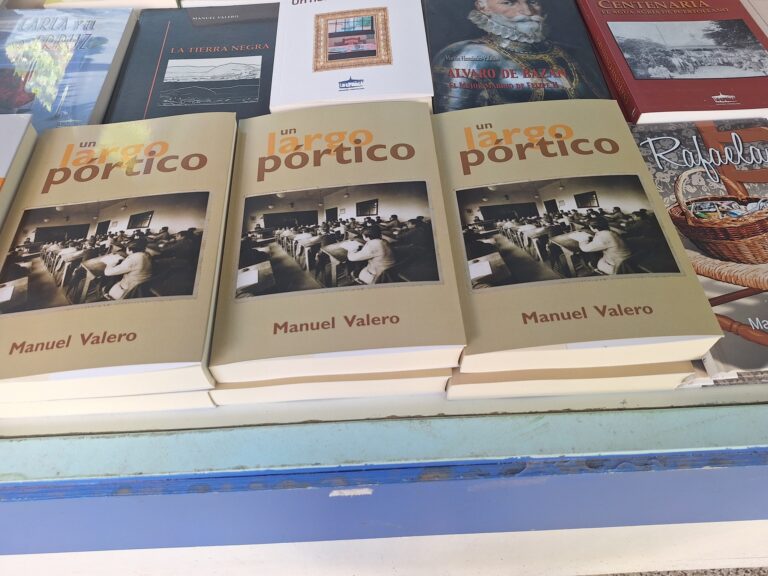 El periodista y escritor puertollanense Manuel Valero firma este viernes ejemplares de su última novela, «Un largo pórtico,» en la Feria del Libro de Puertollano