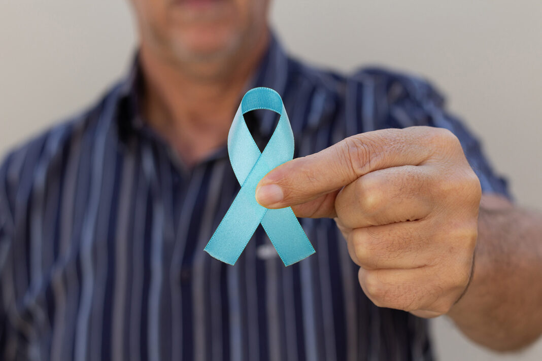 Hand holding a blue ribbon. Blue november