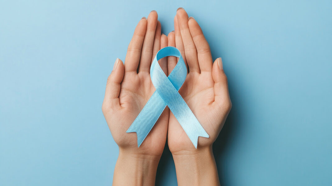 Hands holding a light blue awareness ribbon against a soft blue background, symbolizing support for causes such as prostate cancer awareness or child abuse prevention. Cancer awareness and child abuse prevention